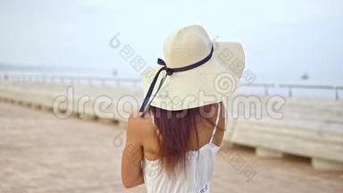 穿着白色裙子戴着帕梅拉帽子走路的漂亮女人
